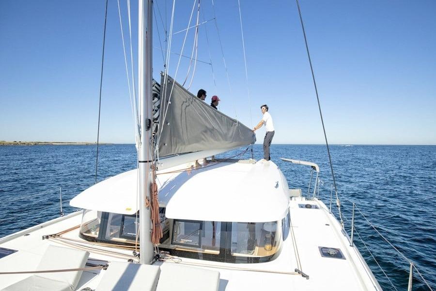 Crew handling the mainsail on the coachroof